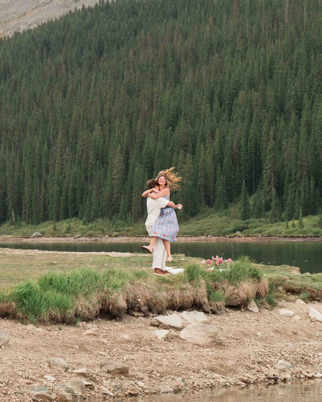 Brock lifting Anna in a hug by the lake